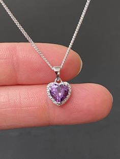 "Sterling Silver Amethyst CZ Heart Necklace Amethyst is the birthstone for February, this makes a great gift for those loved ones born February. Metal: All components are made from solid .925 Sterling Silver Stone: Cubic Zirconia Center Stone size: 7mm Center Stone Carat Weight: 1.6ct Measurement: pendant height is 14mm (0.55\") including bail and 10mm (0.39\") wide Choose Chain Length At Checkout Please feel free to Convo me with any questions before purchasing. Please view policy before purcha Purple Heart Pendant, Silver Pendant Design, Necklaces Purple, Birth Stone Necklace, Purple Heart Necklace, Necklace Purple, Lavender Jewelry, Pendant Designs, Necklaces Silver