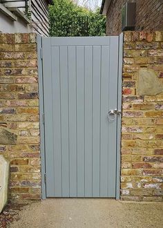 an open grey door on a brick wall