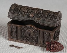 an old wooden box with carvings on it and a piece of metal next to it