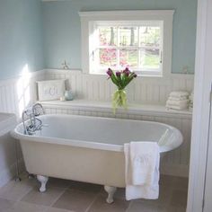 a white bath tub sitting in a bathroom next to a window