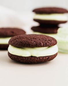 three cookies with white frosting and chocolate on top, one is covered in green icing