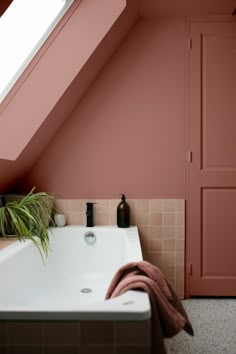 a bath tub sitting under a skylight in a bathroom