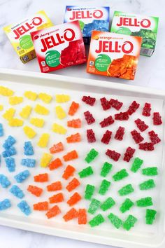 gummy bears and jello are sitting on a white tray next to each other