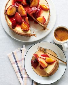 there is a pie with fruit on it and a cup of coffee next to it