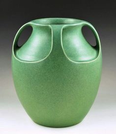 a green vase with two holes in the middle