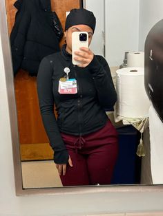 a woman taking a selfie in front of a bathroom mirror with her cell phone