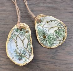 two ornaments hanging from twine on top of a wooden table