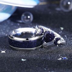 two wedding rings sitting on top of each other in front of some confetti