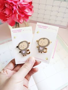 someone is holding up two cute monkey pins