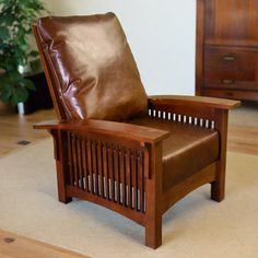 a brown leather chair sitting on top of a carpeted floor next to a wooden dresser