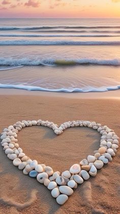 a heart made out of rocks on the beach