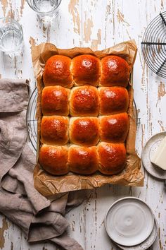 a pan filled with bread sitting on top of a table next to plates and utensils