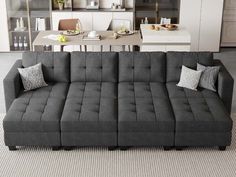 a gray couch sitting on top of a rug in a living room next to a table