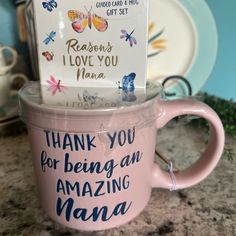 a pink coffee cup sitting on top of a counter next to a sign that says, thank you for being an amazing mama