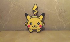 a lego pikachu is sitting on a table in front of a wallpapered background