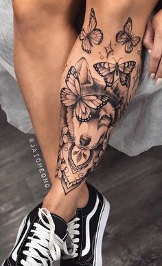 a woman's leg with tattoos and butterflies on it