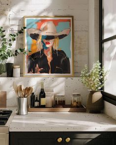 a kitchen counter with a painting on the wall above it and various utensils