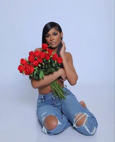 a woman sitting on the floor with roses in her hands