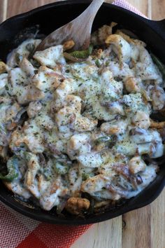 chicken and broccoli casserole in a skillet with a wooden spoon