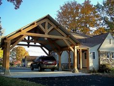 a car is parked in front of a house with an attached carport on the driveway