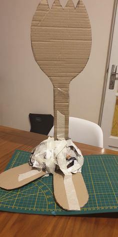 a piece of cardboard sitting on top of a cutting board next to a knife and fork