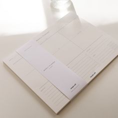 a bottle of water sitting on top of a white table next to a notepad