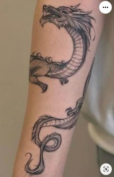 a black and white photo of a dragon tattoo on the arm