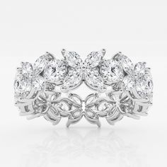 a white gold ring with three pear shaped diamonds on the center and four smaller pears in the middle