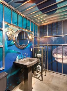 a bathroom with glass walls and a shark painted on the wall next to the sink