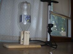 a plastic bottle sitting on top of a wooden block next to a power cord and plugged in