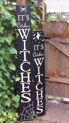 two wooden signs that say it's october and witches on them in front of some plants