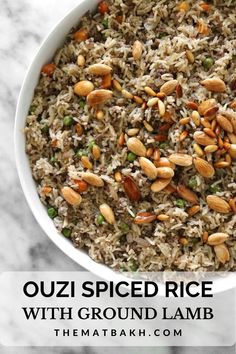 a white bowl filled with rice and nuts on top of a marble countertop next to a