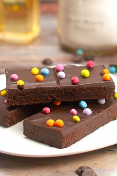 These homemade Cosmic Brownies feature a thick and chewy brownie topped with rich fudge ganache and colorful rainbow chips.