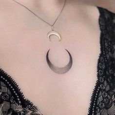 a woman's chest with a crescent pendant on it