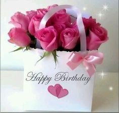 a white bag with pink roses in it and the words happy birthday written on it