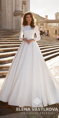 a woman in a white wedding dress standing on steps with her hands on her hips