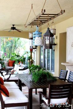 an outdoor living room with lots of furniture and plants on the table in front of it