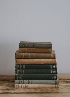 a stack of books sitting on top of a wooden table