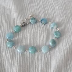 Add a touch of elegance to your wrist with this beautiful larimar beaded bracelet. The larimar gemstones are a stunning blue hue with white marbling. Larimar is a rare gemstone found only in the Dominican Republic, making this bracelet unique and special. It is also believed to have healing properties, bringing a sense of calmness and tranquility to the wearer. This stylish bracelet is perfect for any occasion, whether it's a casual day out or a formal event. It measures approximately 8.5 inches Blue Aquamarine Bracelets For Gift, Blue Aquamarine Bracelets As A Gift, Blue Aquamarine Bracelets As Gift, Handmade Adjustable Larimar Bracelets, Blue Aquamarine Bracelet For Gift, Handmade Blue Aquamarine Bracelets, Blue Aquamarine Bracelet Perfect As A Gift, Turquoise Larimar Bracelets As A Gift, Turquoise Larimar Bracelets For Gifts