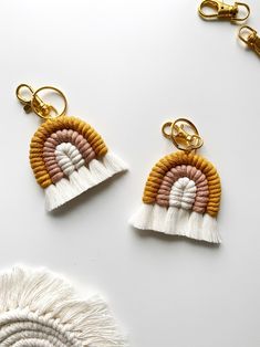 two tasseled earrings are shown on a white surface