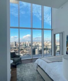 a bedroom with large windows overlooking the city