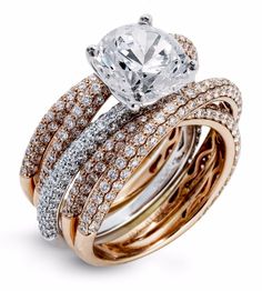 three different rings with diamonds on top and one diamond in the middle, set against each other