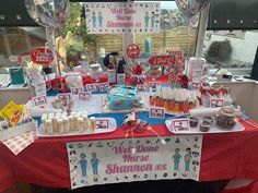 a table topped with lots of cake and candy on top of a red table cloth