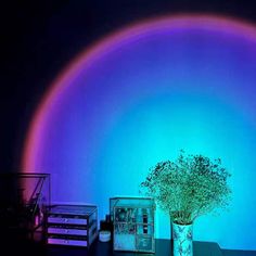 a vase filled with flowers sitting on top of a table under a rainbow colored light