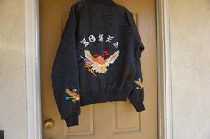 Vintage embroidered KOREA souvenir jacket. Labeled size XL. Good vintage condition. Measurements taken across front lying flat23" armpit to armpit15" across waist26" length Streetwear Long Sleeve Tops With Embroidered Patch, Embroidered Patch Tops For Streetwear In Fall, Casual Cotton Outerwear With Embroidered Cuffs, Fall Outerwear With Floral Embroidery, Spring Streetwear Tops With Custom Embroidery, Spring Embroidered Crew Neck Outerwear, Embroidered Cuffs Long Sleeve Outerwear For Streetwear, Long Sleeve Outerwear With Embroidered Cuffs For Streetwear, Souvenir Jacket