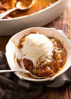 a white bowl filled with ice cream next to a casserole dish on a wooden table