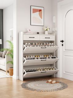 a living room with white furniture and a large rug in front of the door that has an open shoe rack on it