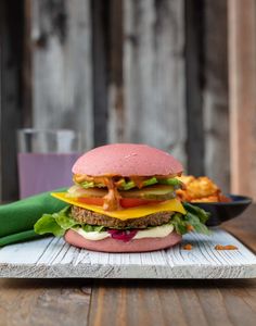 a large hamburger sitting on top of a wooden table