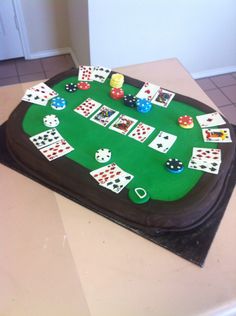 a cake shaped like a table with playing cards and dice on it, sitting on top of a counter