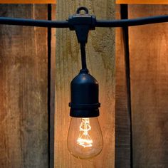 an old fashioned light bulb is hanging on a clothes line with two lights attached to it